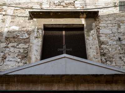 ...sovrastata da un frontone triangolare con una croce in ferro